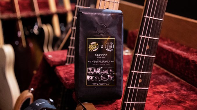 Un primer plano de una bolsa de café negro de frijoles.  Se encuentra en medio de un juego de guitarras eléctricas.